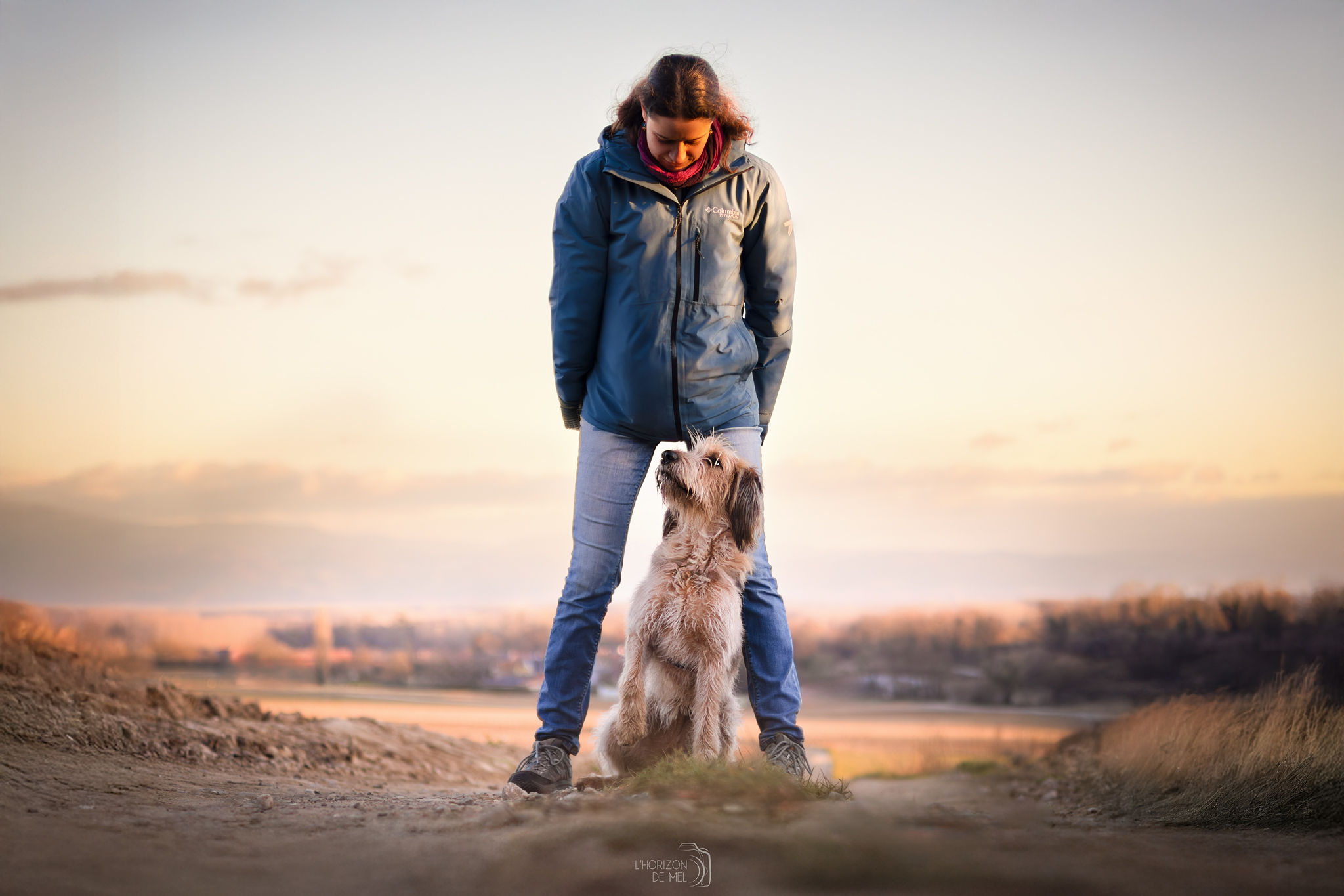 Julie et son chien socca dans les champs au couché du soleil